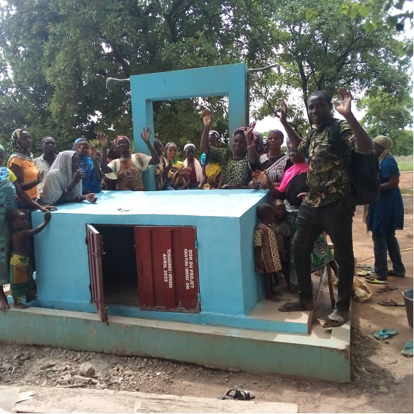 Die Trinkwasseranlage ist fertig! Projektleiter Michée (rechts) und Bewohner Image